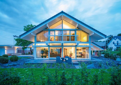 Ein elegantes, modernes Haus mit gläserner Fassade und Garten