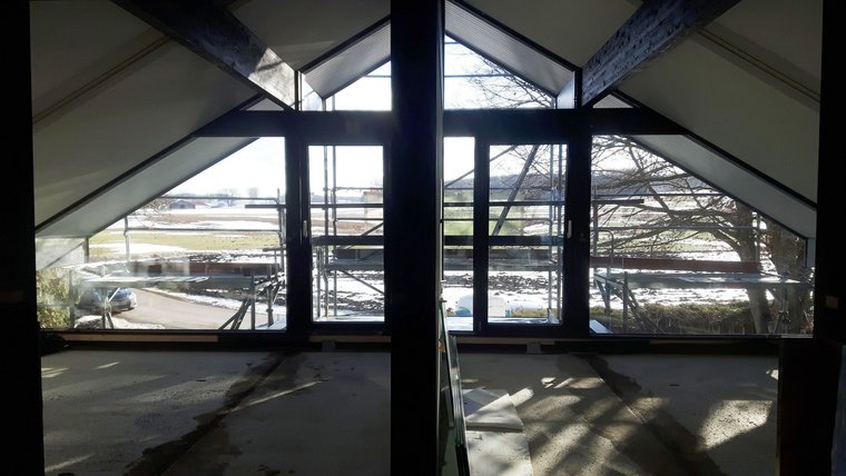 Blick aus einem modernen, offenen Raum mit großen Fenstern Blick auf eine Landschaft durch große Fenster in einem Neubau
