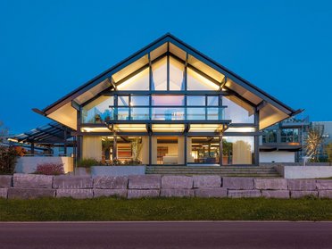 Elegantes Haus mit Glasfassade und stilvollem Design bei Nacht