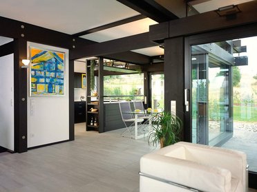 Moderne Wohnräume mit Blick auf die Natur Innenansicht eines modernen Wohnraums mit Kunst und großen Fenstern