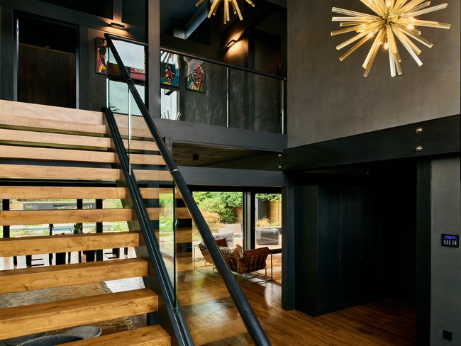 Innenansicht eines HUF Hauses mit Holztreppe und modernen Lampen
