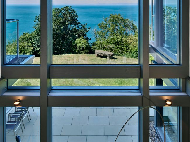 HUF Haus am Meer: Modernes Designhaus mit Meerblick Blick durch große Fenster auf das Meer und die Umgebung des HUF Hauses