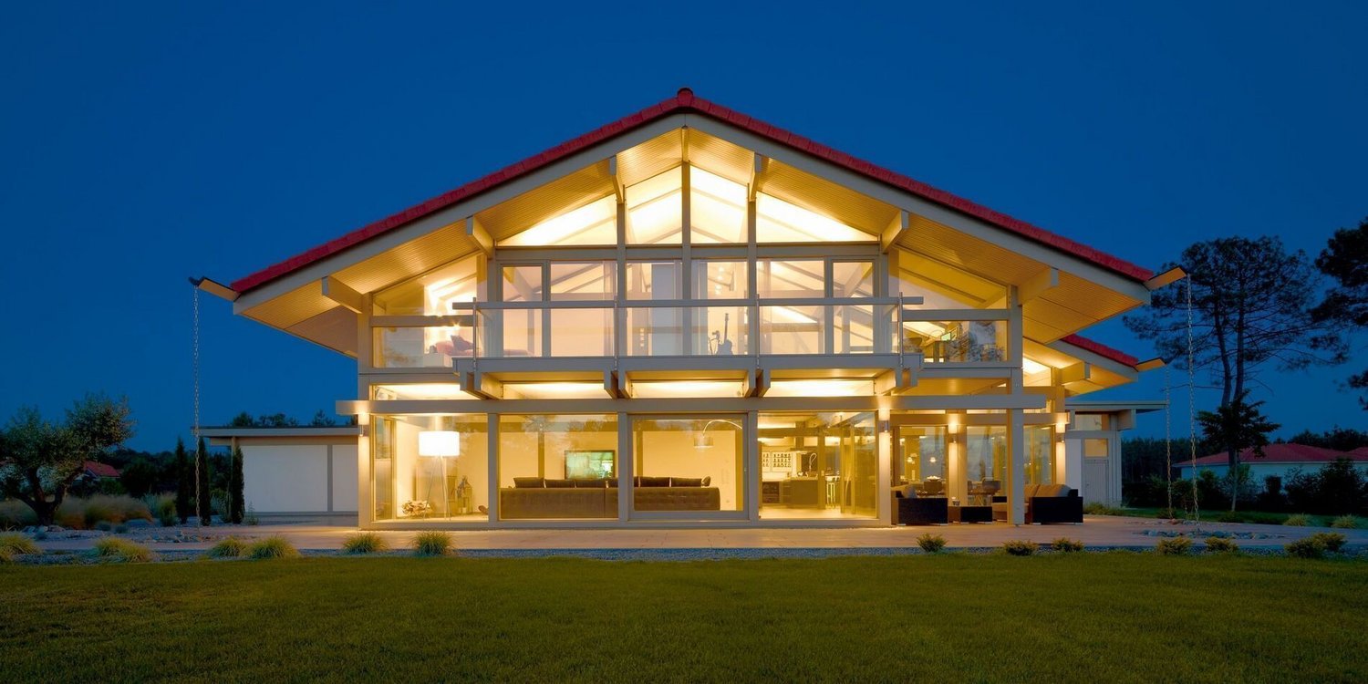 HUF Haus mit großen Fenstern und beleuchtetem Innenraum