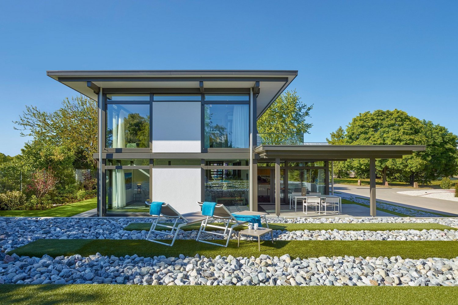 Ein stilvolles, modernes Haus umgeben von Garten und Steinen