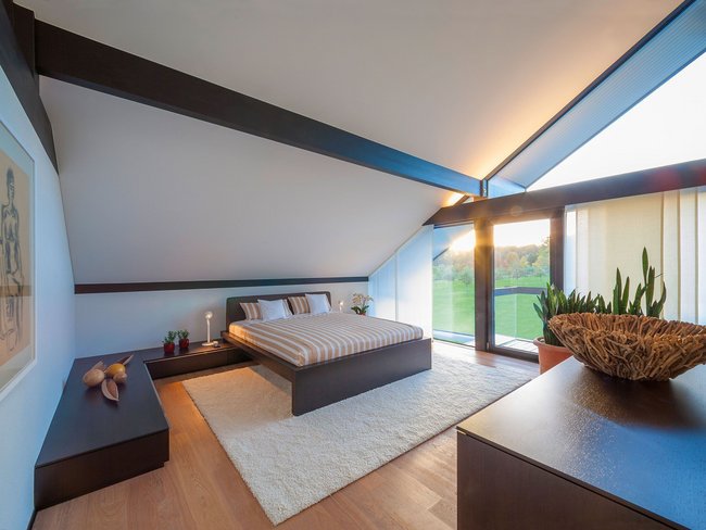 Helles Schlafzimmer mit Holzdetails und Aussicht nach draußen
