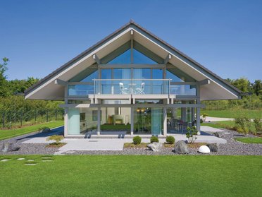 Ein modernes Haus mit Glasfront und Grüngarten im Freien