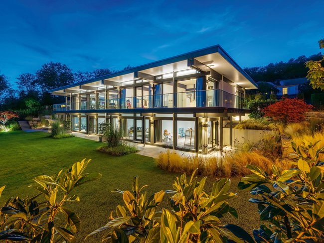 Modernes HUF Haus mit Flachdach und klaren Linien bei Nacht