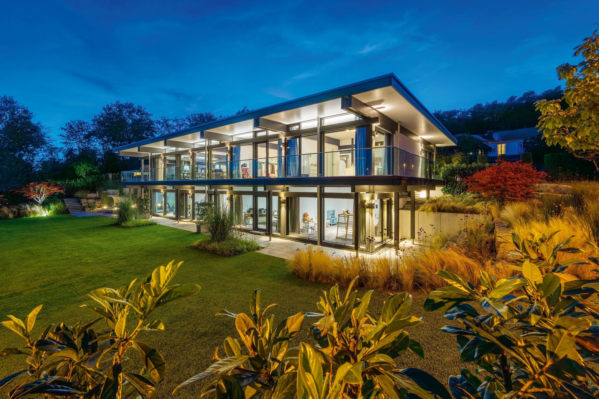 Modernes HUF Haus mit Flachdach und klaren Linien bei Nacht