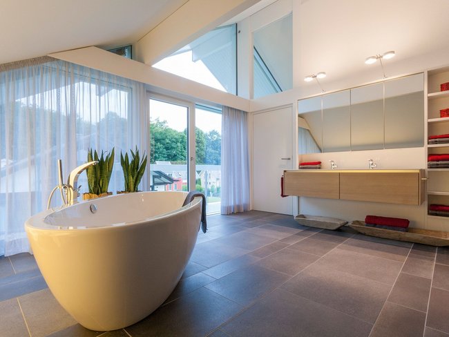Elegantes Badezimmer mit Whirlpool, Pflanzen und viel Tageslicht