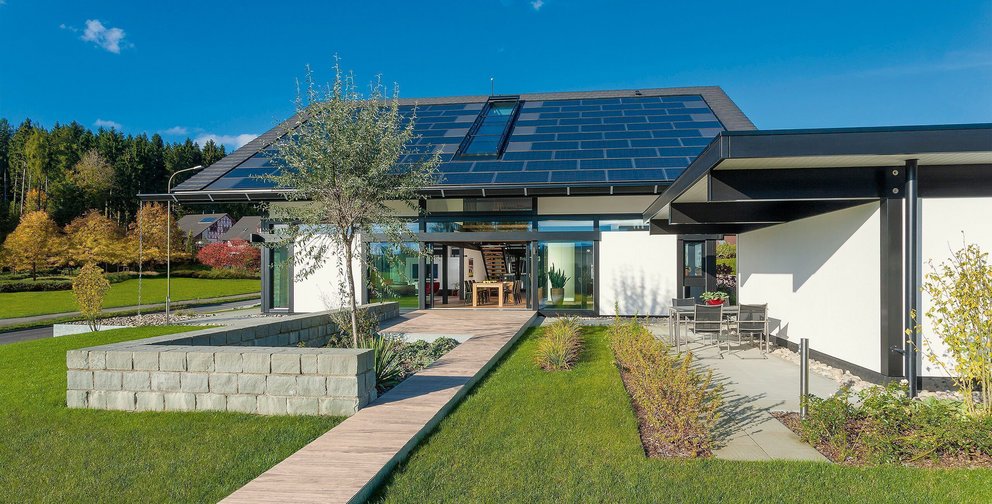 Haus mit Solarpanelen, Garten und modernem Design in ländlicher Umgebung