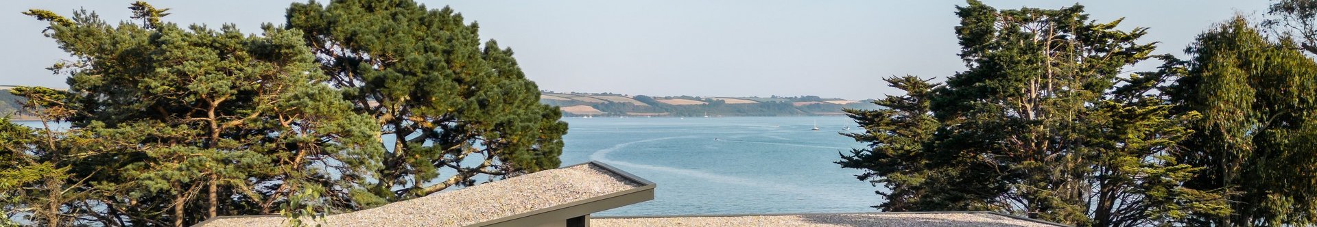 Spektakuläres Fachwerkhaus mit Meerblick Fachwerkhaus umgeben von Blumen und Bäumen mit Blick auf das Wasser