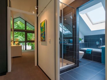 Helle Badezimmeransicht mit Dusche und Badewanne, angrenzender Flur
