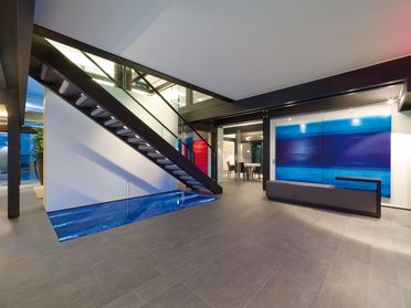 Eleganter Wohnbereich mit Treppe und modernem Kunstwerk