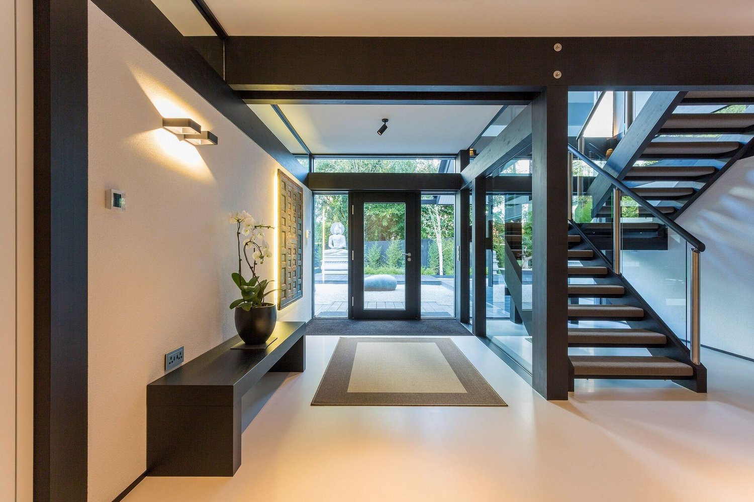 Offener Eingangsbereich eines modernen Hauses mit Glasfassade und Treppe
