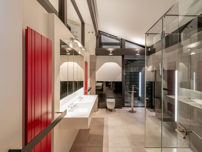 Modernes Badezimmer mit Glaswänden und roten Akzenten Heller Raum mit modernen Sanitäreinrichtungen und stilvollen Oberflächen