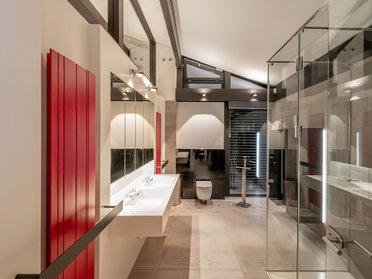 Modernes Badezimmer mit Glaswänden und roten Akzenten Heller Raum mit modernen Sanitäreinrichtungen und stilvollen Oberflächen