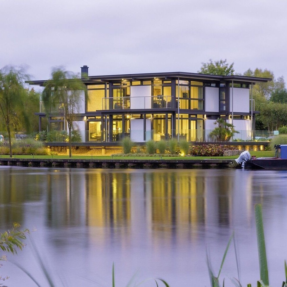 Modern house by the water at twilight Contemporary architecture reflecting on a calm water surface