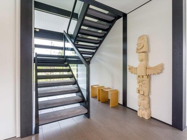 HUF house modum 810 21 Innenansicht eines Architektenhauses mit offener Treppe und kunstvoller Holzskulptur