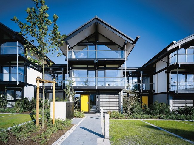 Moderne Architektur eines Wohnhauses mit Balkonen Fassade eines modernen Wohnhauses mit angrenzenden Gärten und Eingängen