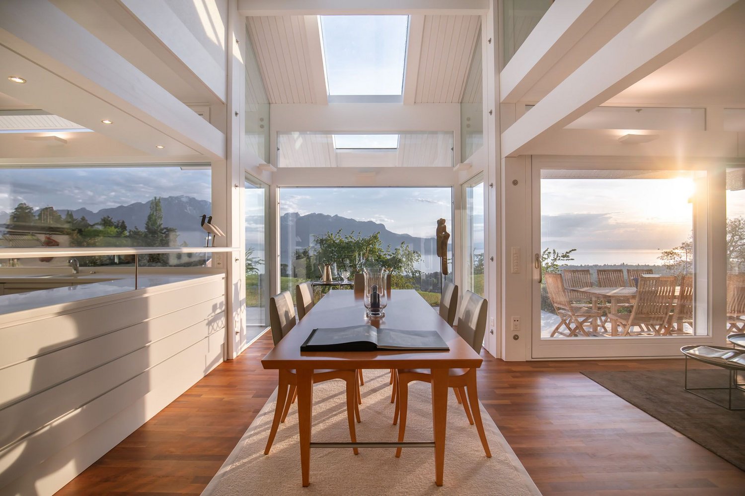 Helles Esszimmer mit großen Fenstern und Blick auf die Landschaft