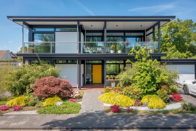 HUF Modum Flachdach-Haus mit buntem Garten und Pflanzen