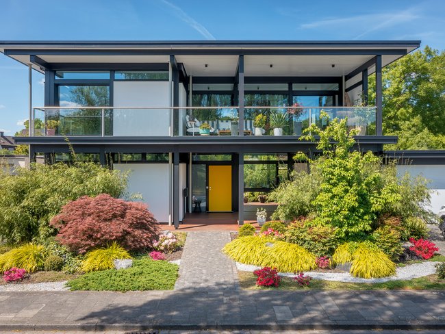 Modernes Designhaus mit Flachdach und gepflegtem Garten HUF Modum Flachdach-Haus mit buntem Garten und Pflanzen
