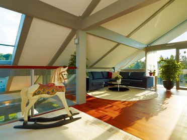 Innenansicht eines modernen Hauses mit Holzschaukelpferd und eleganter Einrichtung