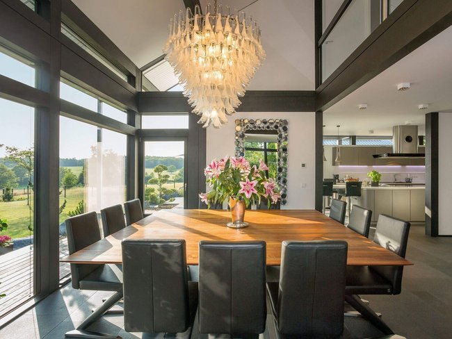 Moderne Architektur und Design im Essbereich Heller Essbereich mit Holztisch, eleganter Beleuchtung und Blick ins Freie