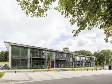 Fertighäuser in Hybridbauweise umgeben von Grünflächen