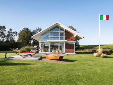 Modernes Familienhaus in einer grünen Umgebung mit italienischer Flagge