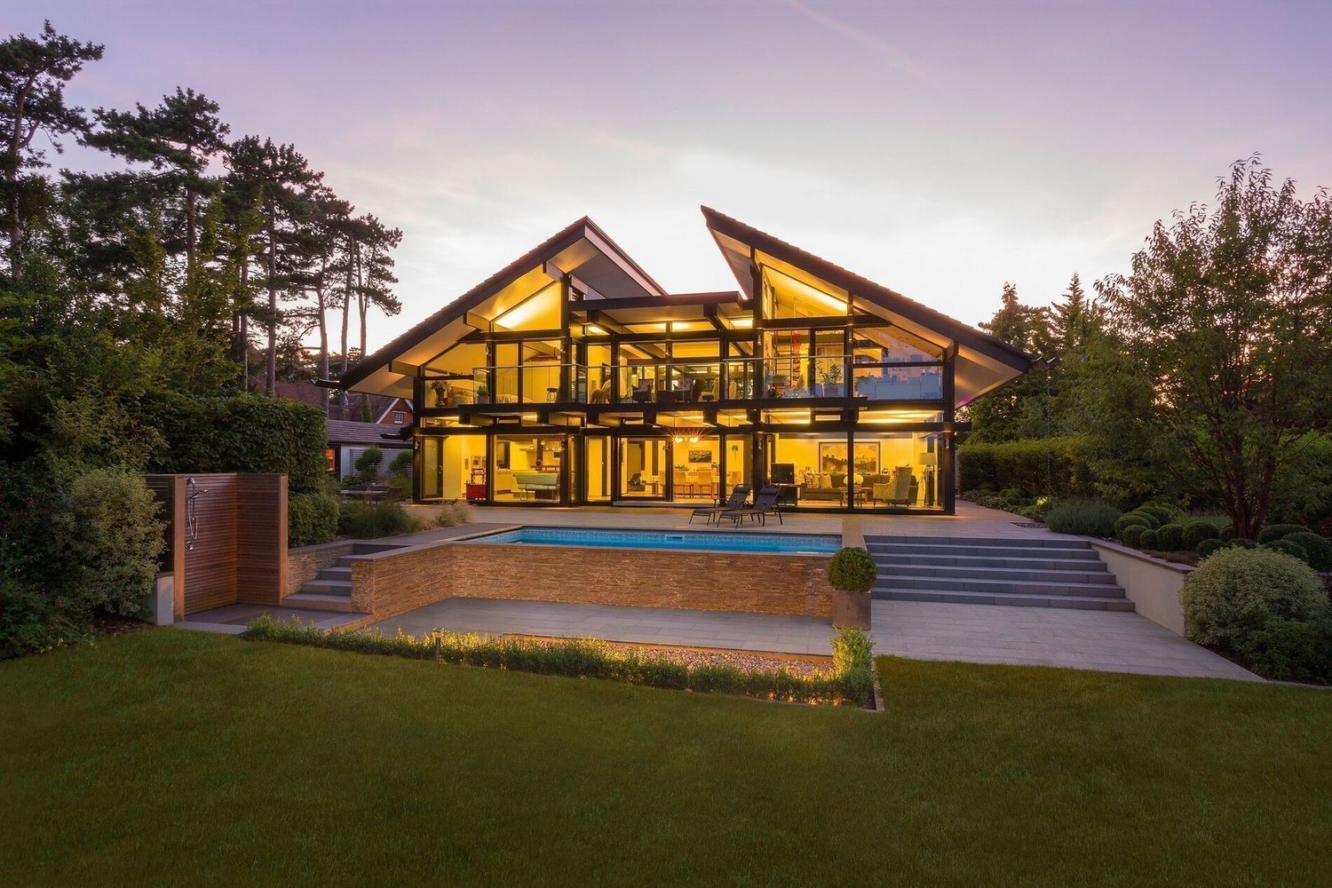 Elegantes Haus mit großen Fenstern und Pool in der Natur