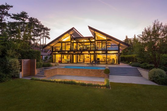Elegantes Haus mit großen Fenstern und Pool in der Natur