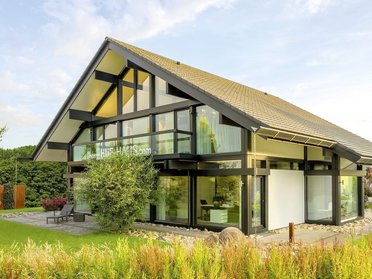 Eine zeitgenössische Villa mit großen Fenstern und Garten