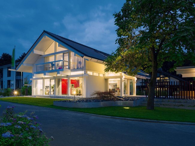 Schön beleuchtetes modernes Haus mit Garten und Straße