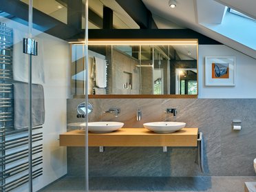 Helles Badezimmer mit Doppelwaschbecken und modernen Elementen