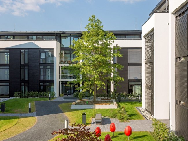 Ansicht eines Bürogebäudes mit Garten und modernen Designelementen