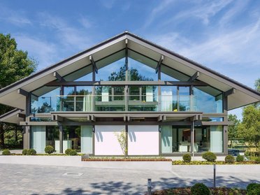 Elegantes Haus mit großzügigen Fenstern und grünem Umfeld