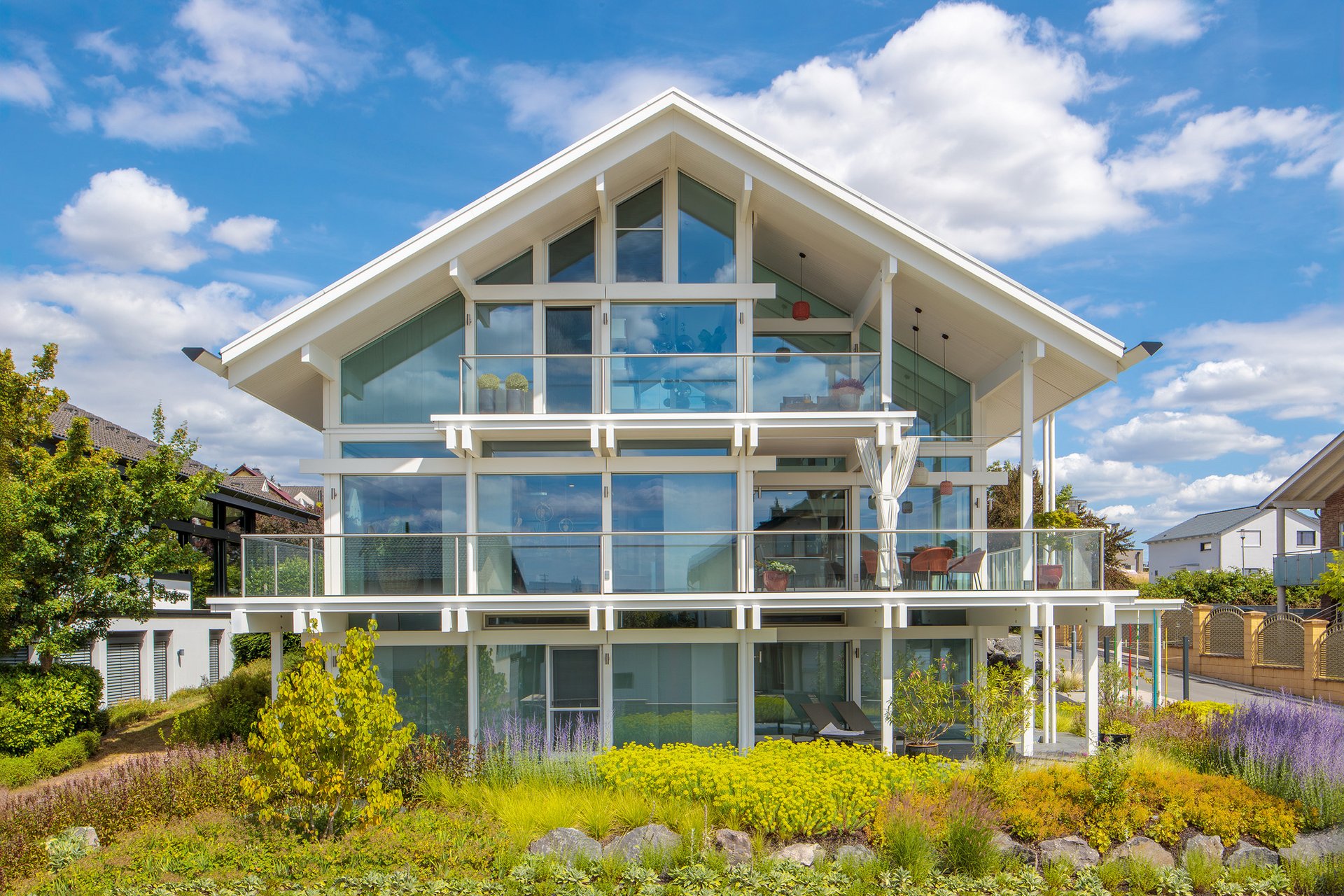 Ein modernes Fachwerkhaus mit großen Fenstern und Gartenlandschaft