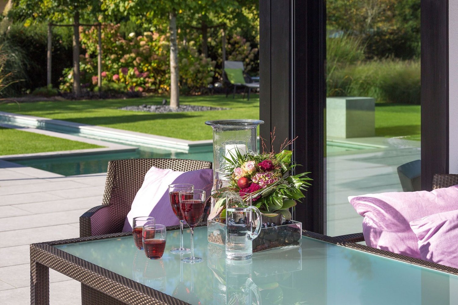Modernes Wohnambiente mit Glas und Holz im Garten mit Blick auf das Panorama