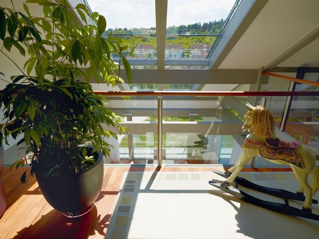 Innenansicht eines HUF HAUS mit Pflanzen und einem Holzspielzeug