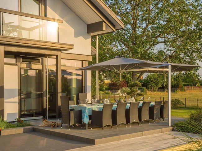 Moderne Architektur mit Außenterrasse und Designermöbeln Schöne Terrasse mit modernen Möbeln und Sonnenschutz, umgeben von Natur