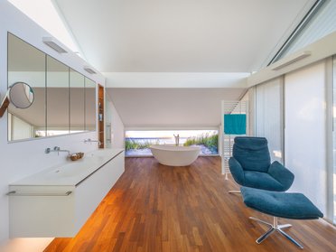 Helles, modernes Badezimmer mit Badewanne und Holzfußboden
