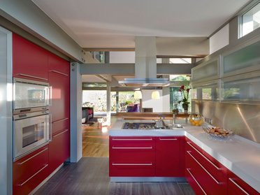 HUF Haus ART 3 grau Fachwerkhaus 7 Helle Küche mit roten Schränken und Edelstahl-Oberflächen in einem Holz-Glas-Haus