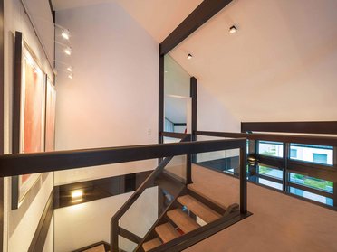 HUF Haus modum 810 Musterhaus Wuppertal 11 Lichtdurchflutetes Treppenhaus mit Kunstwerken an der Wand