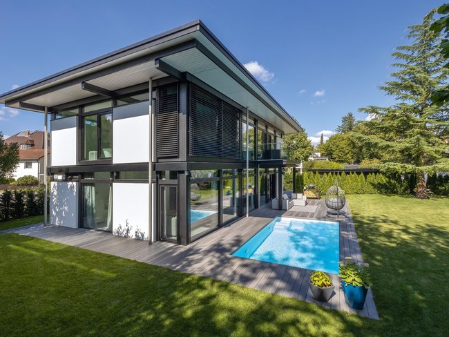Modernes lichtdurchflutetes Architektenhaus mit Pool Architektenhaus mit Glasfassade und Pool im Garten