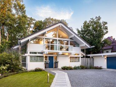 Modernes HUF Haus mit großen Fenstern und Gartenblick