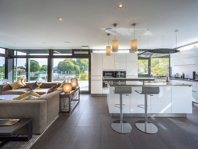 Elegantes Wohnzimmer mit Panoramafenstern und moderner Kücheneinrichtung
