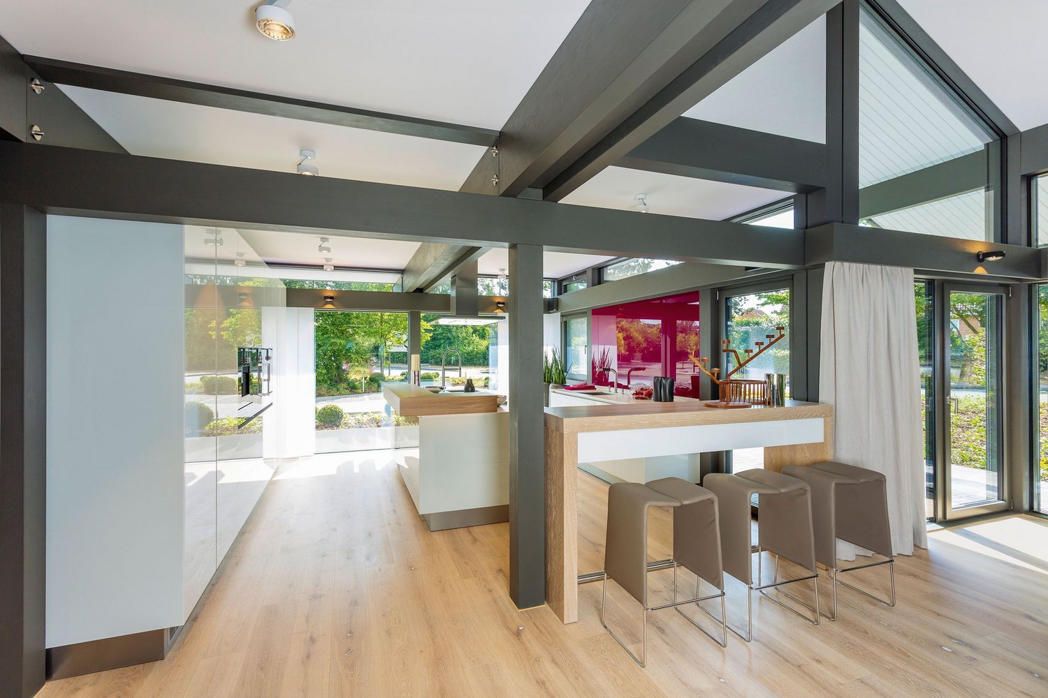 Heller Raum mit Holz- und Metallelementen, offenen Fenstern und einer Bar