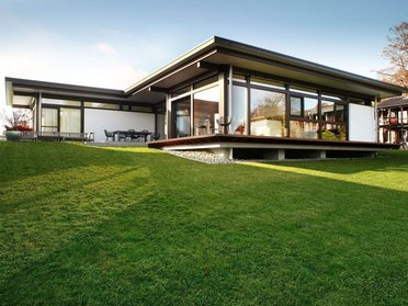 Moderne Architektur: Bungalow mit großem Garten Architektenhaus mit Glasfassade und Grünfläche im Vordergrund
