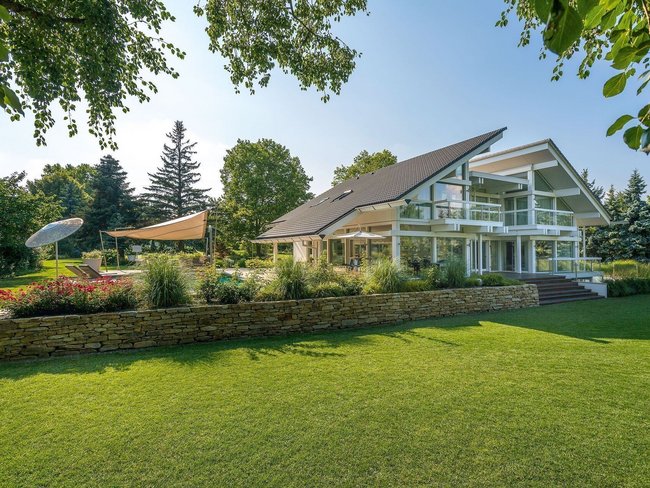 Moderner Garten mit großzügigem Fachwerkhaus und Terrassenflächen